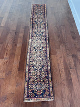 a skinny antique farahan runner with a blue field and a pink floral design