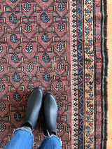 a large antique kurdish rug with a pink and blue palette