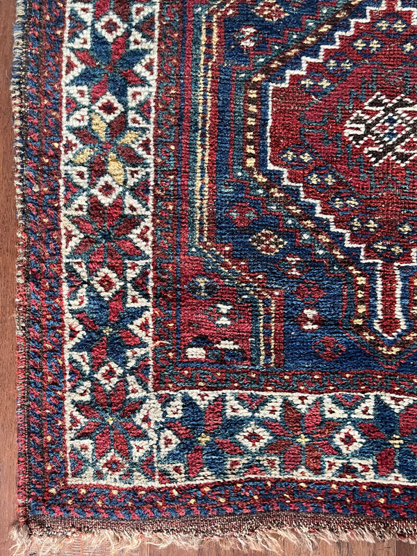 a mini antique shiraz rug with a classic red and blue palette
