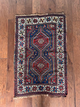 a mini antique shiraz rug with a classic red and blue palette