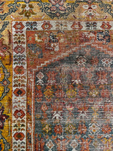 an antique oushak rug with a yellow border and grey field 