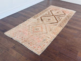 an antique turkish rug with brown and pink accents