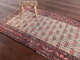 an antique malayer rug with a pink floral pattern on an ivory field