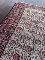 an antique malayer rug with a pink floral pattern on an ivory field