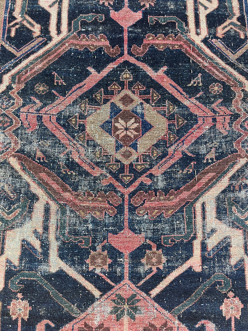 a vintage mahal rug with pink and teal accents on an indigo field