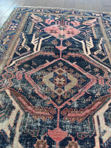 a vintage mahal rug with pink and teal accents on an indigo field