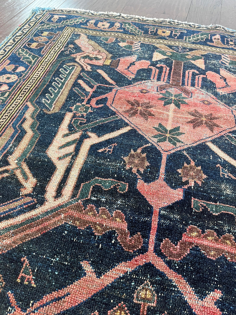 a vintage mahal rug with pink and teal accents on an indigo field