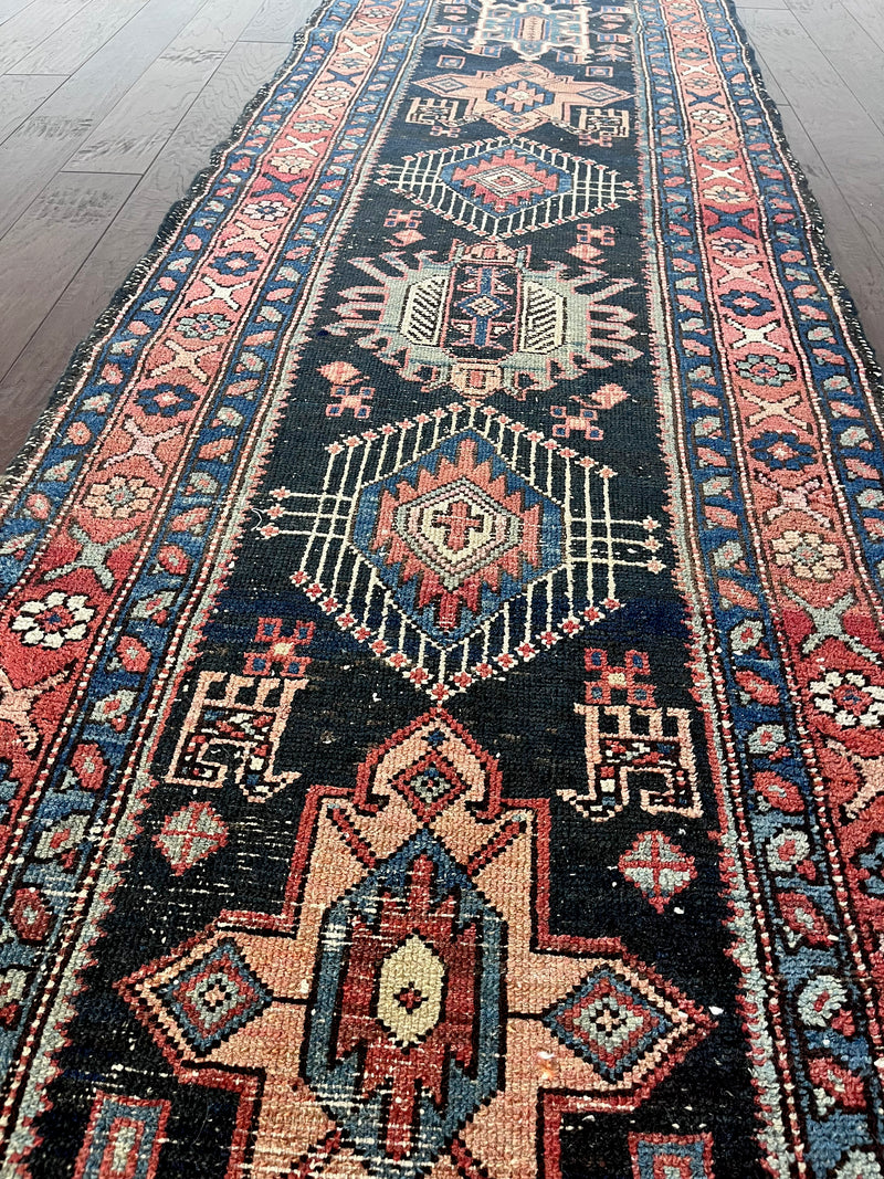 an antique heriz runner with a navy blue field