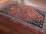 an antique qashqai rug with a red and blue palette and large central medallion