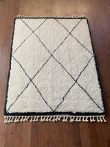 a vintage beni ourain rug with large black diamond pattern