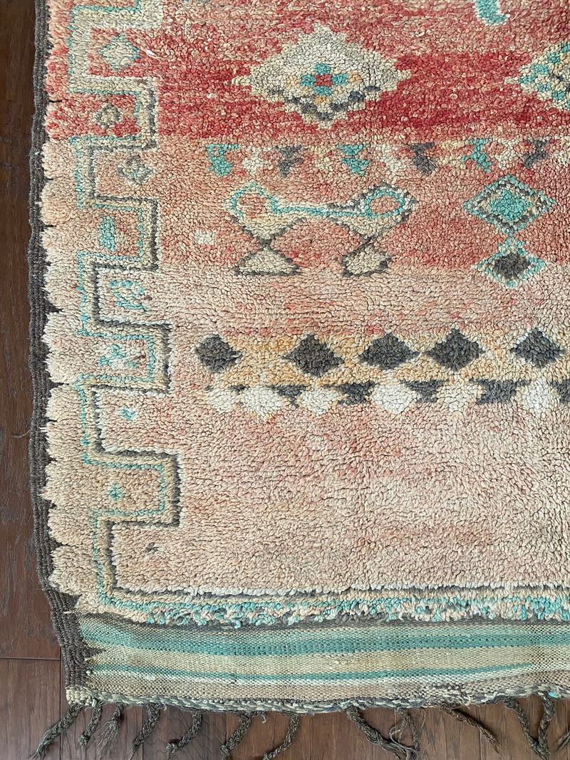 a vintage berber rug with pink abrash and taupe and turquoise accents