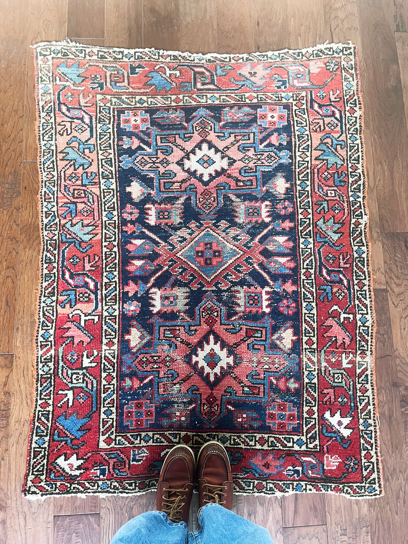 a mini antique heriz rug with colorful palette