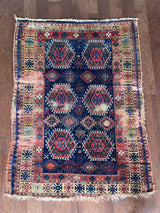 an antique kurdish rug with a royal blue field and a bright geometric pattern