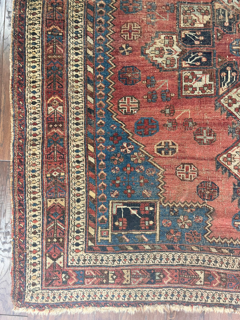 a coral toned afshar rug with a large cream medallion