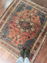 a coral toned afshar rug with a large cream medallion