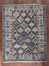 a medium size caucasian rug with a blue, brown and cream palette