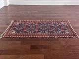 an antique baluch rug with a royal blue field and coral accents
