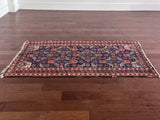 an antique baluch rug with a royal blue field and coral accents