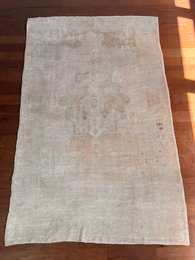 a vintage turkish rug with soft salmon hues and a fawn accents