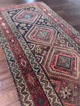 an antique malayer runner with warm rust and pink accents with blue undertones