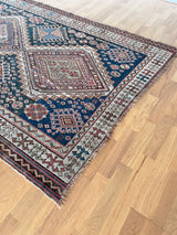 an antique caucasian shirwan rug with a blue palette and coral accents
