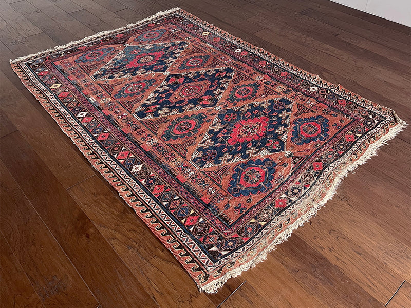 a medium caucasian sumac rug with a rusty field and hot pink accents