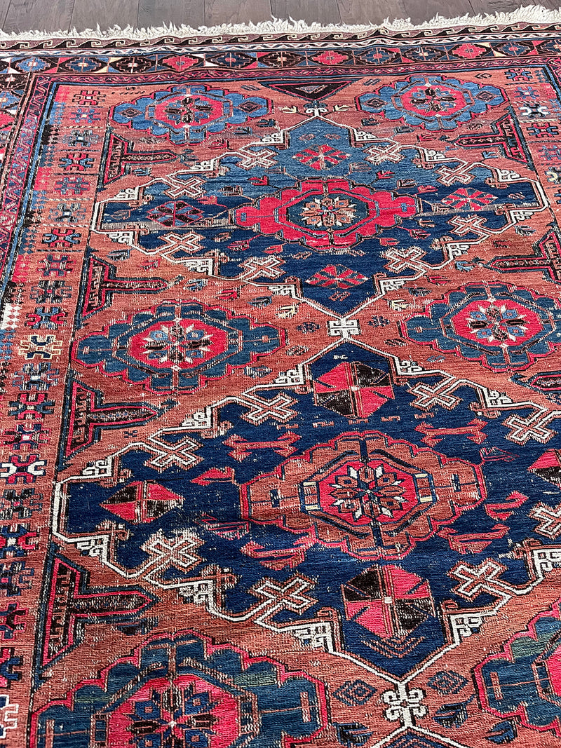 a medium caucasian sumac rug with a rusty field and hot pink accents