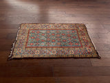 a mini antique rug with a blue field and earthy red accents