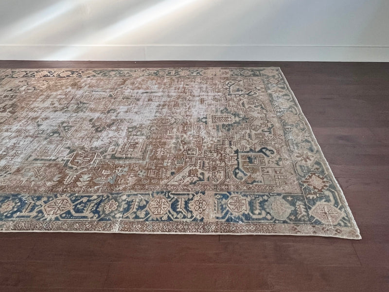 a large antique heriz rug with neutral cream and blue accents