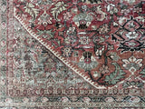 an antique mahal rug with a red/pink toned field and green and brown floral accents