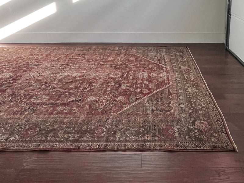 an antique mahal rug with a red/pink toned field and green and brown floral accents