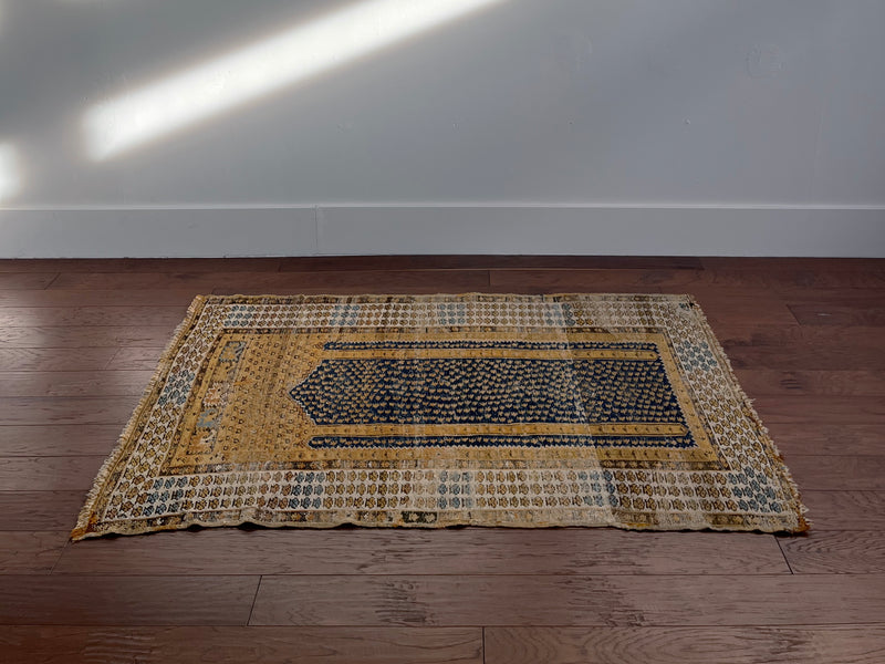 an antique turkish kula rug with mustard tones and dark blue accents